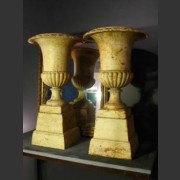 PAIR OF FRENCH PAINTED CAST IRON URNS ON PLINTHS